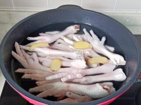 鸡爪冷水下锅，放入姜片 。