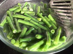 放入豆角煮熟，捞出放入冷开水中浸泡一会儿