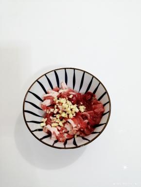 肉丝放入碗中，加入蒜末