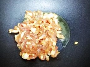 锅里加入适量的油，然后把肉丝放入锅中