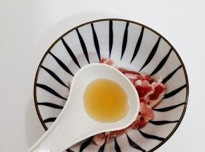 五花肉洗干净，切成薄片，然后加入料酒搅拌均匀，腌制15分钟
