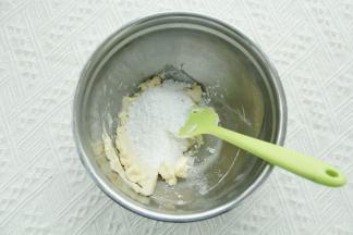 软化到可以用刮刀轻松抹开，倒入盐和糖粉（糖粉颗粒小，让面团的延展性变低，有助于曲奇烤出花纹保持）