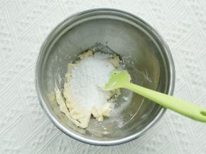 软化到可以用刮刀轻松抹开，倒入盐和糖粉（糖粉颗粒小，让面团的延展性变低，有助于曲奇烤出花纹保持）