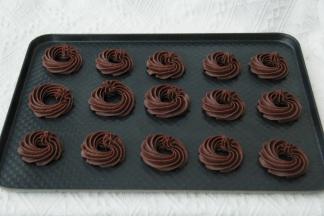 右手拿裱花袋，左手捏裱花嘴，垂直在烤盘上方。匀速挤出曲奇糊，逆时针或者顺时针一圈，尾部轻轻往下压，然后提起收尾！