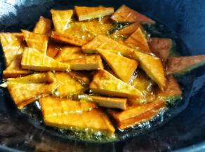 锅中加多点油烧至8成热，加入香干煎至变脆。