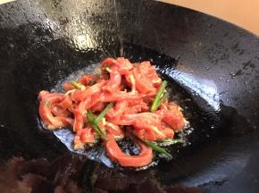 再热锅烧适量油，油温6成热放入腌制好的牛肉，大火炒至断生，捞出备用