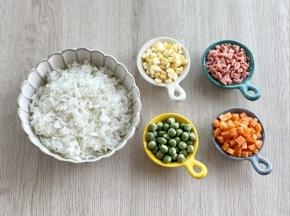 玉米粒剥好，豌豆洗净，胡萝卜去皮切小丁，火腿肠切碎。