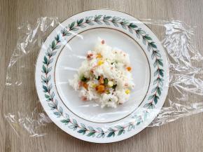 取一张保鲜膜，中间加入60克拌好的米饭；