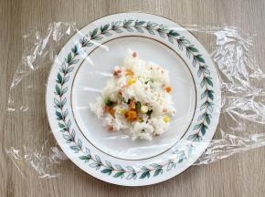 取一张保鲜膜，中间加入60克拌好的米饭；