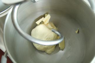 气温过高可加冰袋控制面温。一档混合到无干粉，转4档打到面团略光滑挂钩，能扯出粗膜。加黄油。