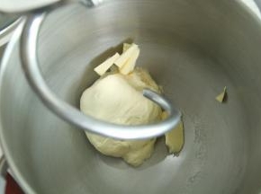 气温过高可加冰袋控制面温。一档混合到无干粉，转4档打到面团略光滑挂钩，能扯出粗膜。加黄油。