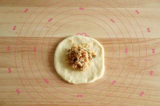 取一松弛好的面团，擀开翻面，放上1/6馅料。