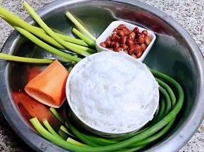 准备原材料蒜苗摘去两端洗净胡萝卜去皮洗净花生米在油中炸至变色酥脆粉丝在开水中煮熟后立即捞出放入冷水中过凉再沥干水份备用