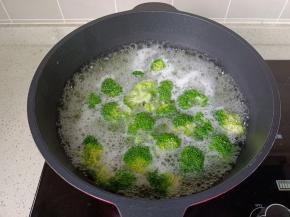 锅里水开放西兰花焯水，焯好水的西兰花控干水分。