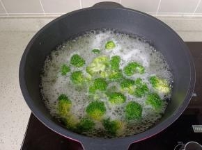 锅里水开放西兰花焯水，焯好水的西兰花控干水分。