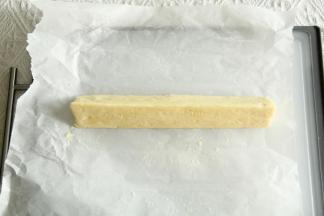 放在油纸上，先搓成圆柱形，再借助刮板或者徒手整理成三角形，裹上油纸冷冻30分钟。