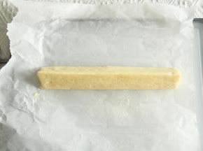 放在油纸上，先搓成圆柱形，再借助刮板或者徒手整理成三角形，裹上油纸冷冻30分钟。