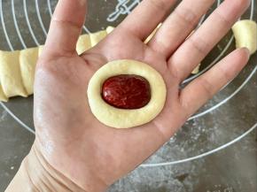 在面团中间用手指压一个凹槽，把红枣填进去，压紧。