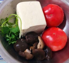准备原材料豆腐、西红柿、香菇去蒂放入开水中焯水断生后立即放入冷水中过凉再沥干水份、香菜