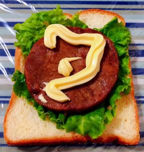 保鲜膜平铺在底部摆上一片吐司放上生菜再摆上牛排淋上沙拉酱