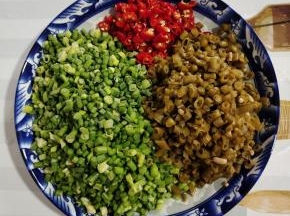 酸豇豆和蒜苔洗净切成小丁，小米辣去蒂切成小圈备用！