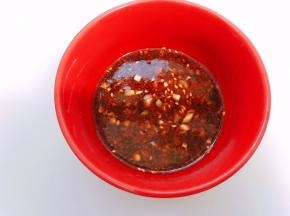 碗里加入蒜末，生抽，白糖和少许纯净水拌匀，再加入醋，蚝油和红油辣椒