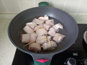 浸泡好的猪脚冷水下锅，放入生姜丝去腥。