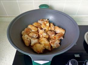 锅里放少许的油，下冰糖小火炒成焦糖色，开大火迅速放入猪脚翻炒上色。