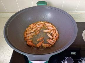 锅里加油放虾头煸炒出虾油捞出。