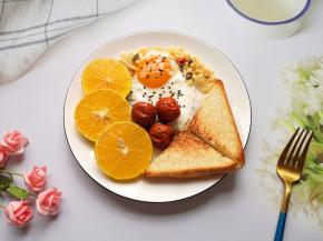 将煎好的吐司片和鸡蛋摆在盘子里，皇帝柑切成片，再加入两勺水果麦片，放上3个脆枣。