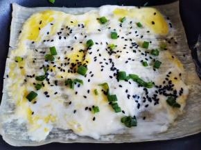 打入鸡蛋刷匀，撒黑芝麻和葱花，定型后翻面刷一层酱料，