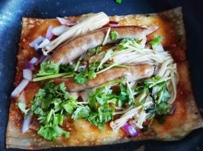 撒洋葱碎+香肠+金针菇+香菜煎熟。