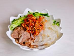 海蜇，黄瓜，牛肉，熟花生放入盘中，淋上酱料。