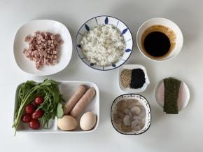 米饭备好，午餐肉切成小丁，香肠上划菱形网格，鸡蛋打散，虾仁用料酒和黑胡椒粉腌好，芝麻菜洗净，圣女果洗净对半切好