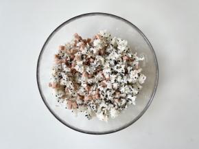 把午餐肉和黑白芝麻倒入米饭中，戴上手套抓匀