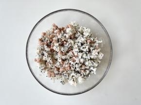 把午餐肉和黑白芝麻倒入米饭中，戴上手套抓匀