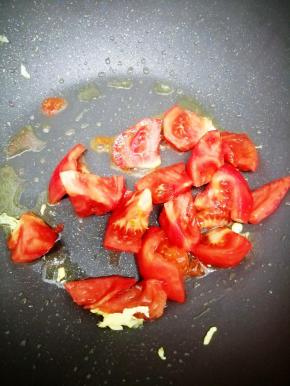 用锅里的余油把西红柿倒入锅中