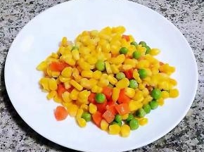 炒好的玉米粒青豆胡萝卜装入盘中