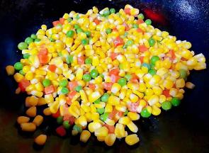 放入玉米粒、青豆、胡萝卜大火快速翻炒均匀