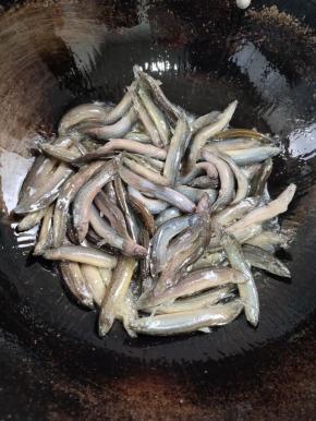 用勺子轻轻的推泥鳅，再不停的晃动锅，调中火慢慢煎至！