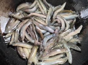 用勺子轻轻的推泥鳅，再不停的晃动锅，调中火慢慢煎至！