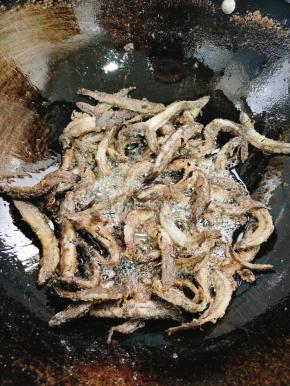 用筷子把泥鳅慢慢的搅散，翻面，大概三分钟左右，煎至泥鳅表面金黄酥脆！
