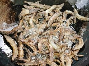 用筷子把泥鳅慢慢的搅散，翻面，大概三分钟左右，煎至泥鳅表面金黄酥脆！