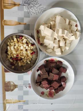 嫩豆腐和鸭血清洗一下，切成小块，蒜瓣剁成蒜末，生姜切成小丁，干辣椒切成段备用！