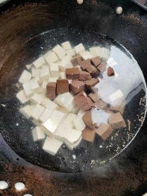 水烧开，放入一勺盐，再放入切好的豆腐和鸭血！（这样可以去除豆腐里面的豆腥味儿，也可以防止豆腐和鸭血在一会儿炖煮的时候煮碎了！）