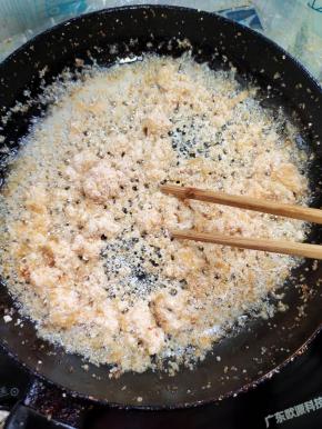 等到鱼籽里面的水份蒸发了，鱼籽不在蹦跶了，打开盖子，用筷子把鱼籽抖散！调小火慢慢煎值，中途记得再用筷子翻动几下！