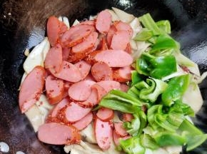 放入青椒和火腿肠翻炒均匀！
