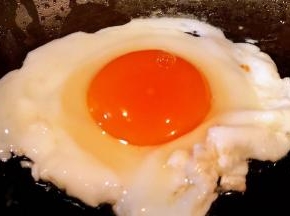 锅中倒入底油加热打入鸡蛋中火煎起来