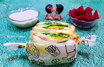 美味可口的午餐肉番茄鸡蛋三明治一切为二用包装纸打包好后大功告成了搭配水果好牛奶一起吃超级棒