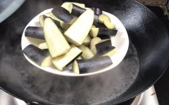 茄子洗净去蒂切成块，放入开水锅中蒸7分钟